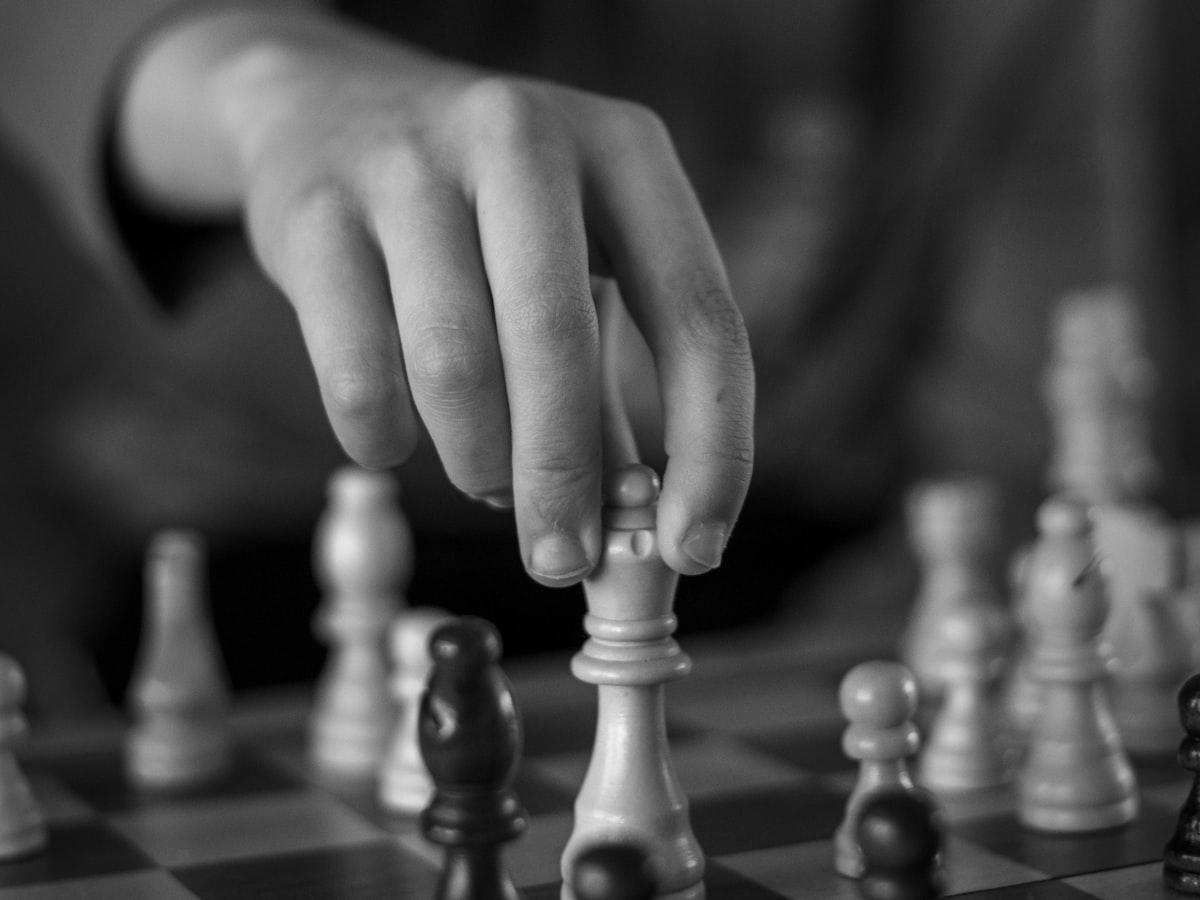 A hand moving a queen on a chessboard