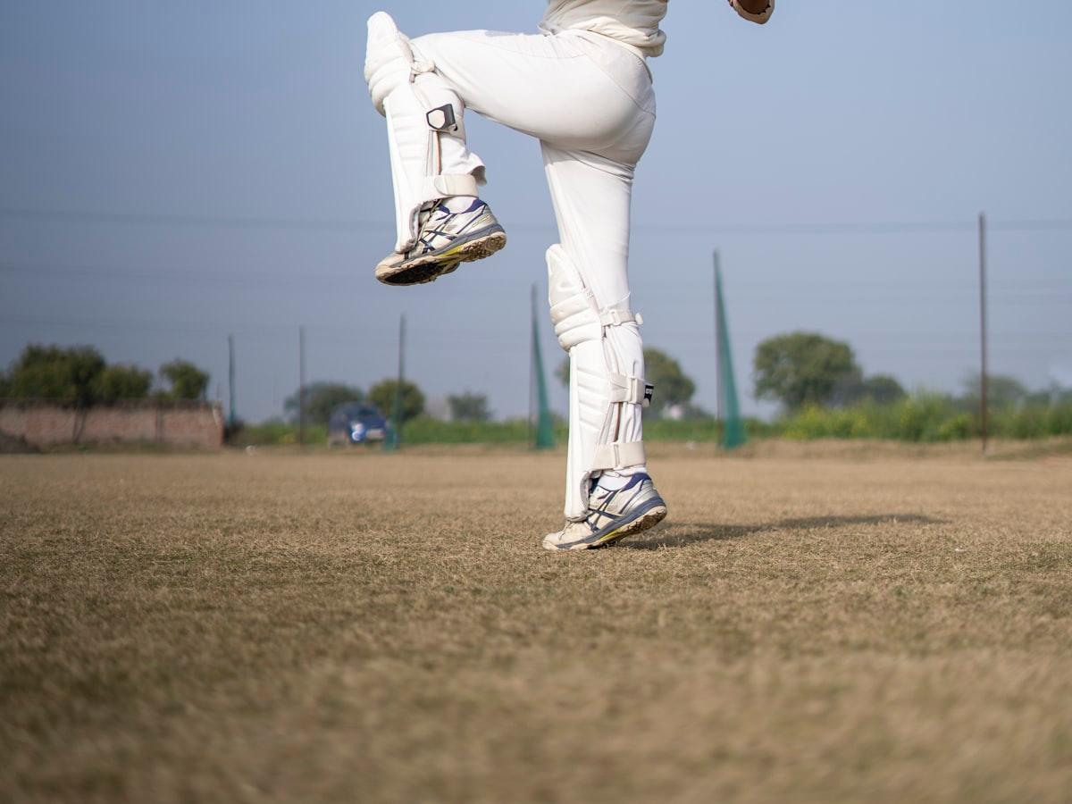 A cricketer in whites playing a shot