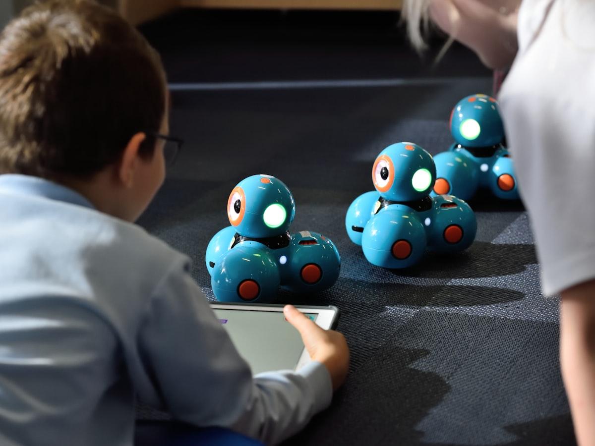 A student programming small robots from a tablet in a robotics class